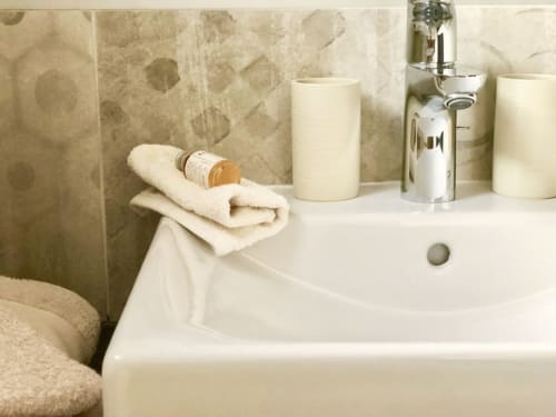 Elegant bathroom sink at Villas Marincelu with cream towel, soap dispenser, and chrome faucet in Serra di Ferro