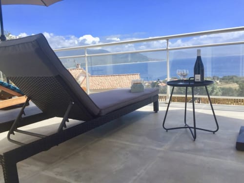 Terrasse luxueuse aux Villas Marincelu avec chaise longue, table à vin et vue sur la mer Méditerranée à Serra di Ferro