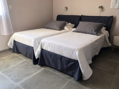 Deux lits jumeaux aux courtepointes blanches et têtes de lit noires dans une chambre des Villas Marincelu, Serra di Ferro