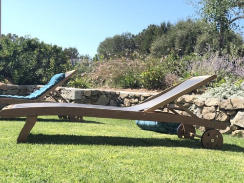 Chaises longues en bois sur pelouse entretenue à l'hôtel Villas Marincelu à Porto Pollo, Corse