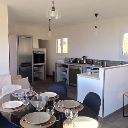 Modern open-plan kitchen and dining area at Villas Marincelu with stainless steel appliances and contemporary furnishings
