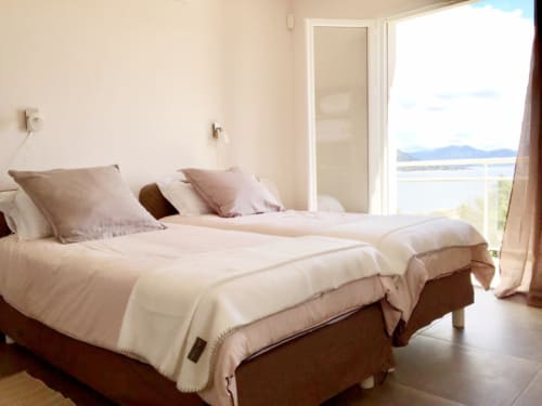 Luxurious bedroom at Villas Marincelu with twin beds, panoramic sea views, and coastal mountain landscape