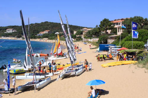 Sailboats and water sports activities on the sandy beach at Villas Marincelu, Porto Pollo, Corsica