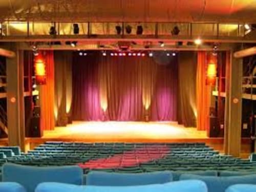 Modern theater stage with red curtains and colorful seating at Villas Marincelu hotel in Serra di Ferro, Corsica