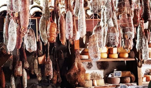 Hanging cured meats and cheeses at traditional Corsican charcuterie shop near Villas Marincelu in Serra di Ferro