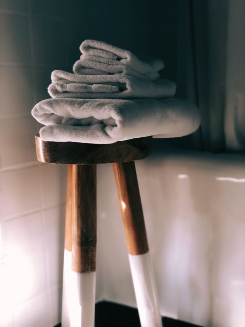 Stack of folded gray towels on wooden stool at Villas Marincelu hotel in Serra di Ferro