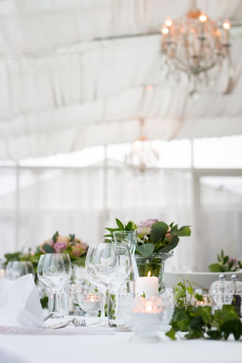 Table élégante de réception de mariage à Villas Marincelu avec verres, compositions florales et ambiance aux chandelles