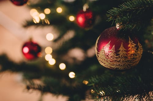 Ornements de Noël festifs avec détails dorés sur sapin décoré à l'hôtel Villas Marincelu