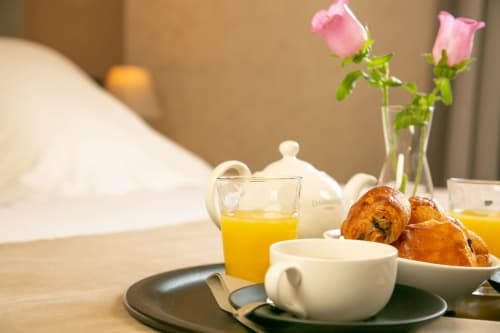 Petit-déjeuner élégant aux Cabines de Houlgate avec viennoiseries, jus d'orange et roses roses