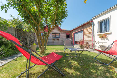 Espace détente du jardin marin de L'escale avec transats rouges, bungalow en bois et pelouse verte à La Rochelle, France