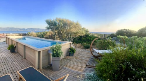 Villas Marincelu pool deck with sea view, wooden terrace, lounge chairs, and Mediterranean garden in Corsica
