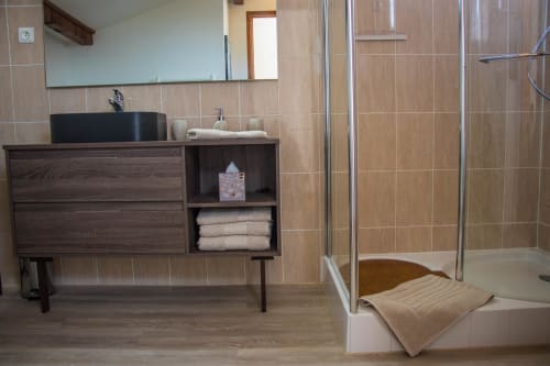 Modern bathroom at Belloréade B&B in Belloc with dark wood vanity, black vessel sink, walk-in shower, and beige tile walls