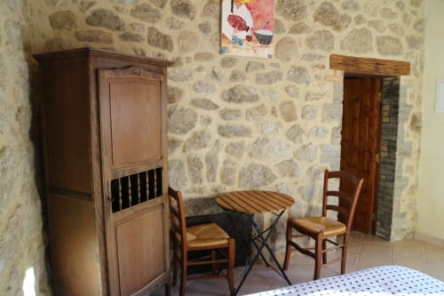 Vue de la chambre : lit double, porte accès salle de bain, table, chaises, armoire