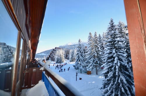 Vue enneigée de la station de ski depuis le balcon de l'appartement Bellecôte Arc 1800, Bourg-Saint-Maurice, avec skieurs et sapins