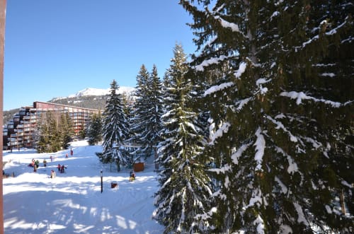 Paysage alpin enneigé de la station de ski Arc 1800 Bellecôte aux ARCS - Paradiski- Bourg-Saint-Maurice, avec skieurs sur les pistes et arbres chargés de neige