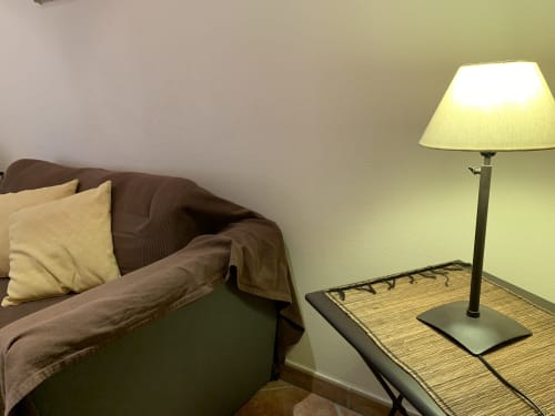 Braunes Sofa mit cremefarbenen Kissen und Stehlampe im Wohnzimmer des La Croix De La Jarrie B&B