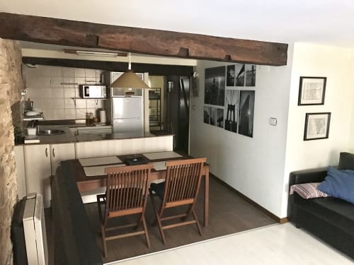 Open-plan kitchen and dining area in 2-bedroom apartment at Urrondo Hotel, Lekeitio with wooden dining table and modern