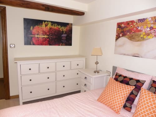 Modern bedroom in Urrondo apartment, Lekeitio with white dresser, pink bedding, and decorative wall art
