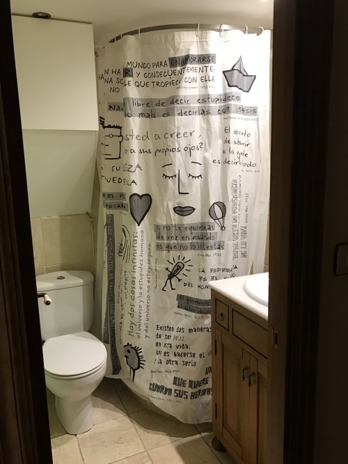 Bathroom in Urrondo apartment, Lekeitio, with toilet, sink, and decorative shower curtain with Spanish text