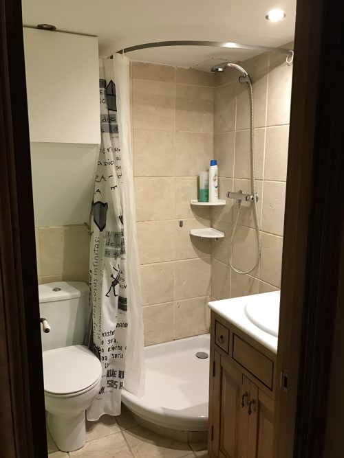 Modern bathroom with shower enclosure, toilet, and vanity in Urrondo apartment, Lekeitio