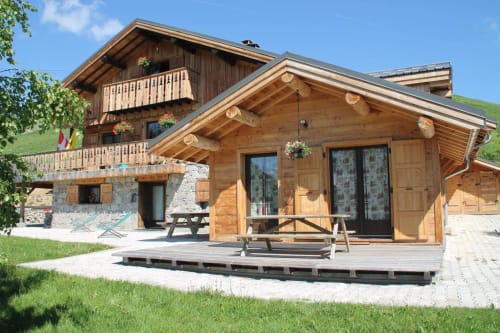 Chalet La Louvière, lodge alpin en bois avec terrasse et tables de pique-nique à Fontcouverte-La Toussuire, France