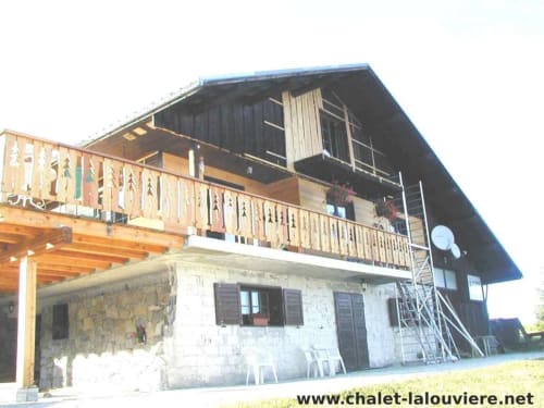 Chalet La Louvière BnB buitenkant met houten balkon en stenen basis, Fontcouverte-La Toussuire