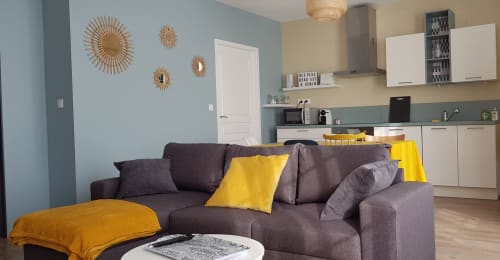 Salon moderne de l'appartement La Java Bleue à La Maison Virginie B&B, Montargis, avec canapé gris et touches de jaune