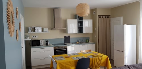 Cuisine moderne et salle à manger de l'appartement La Java Bleue à La Maison Virginie B&B à Montargis avec nappe jaune