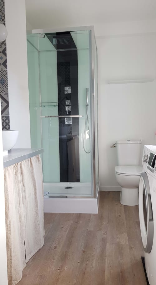 Salle de bain moderne de l'appartement La Java Bleue à La Maison Virginie, Montargis, avec douche vitrée et toilettes