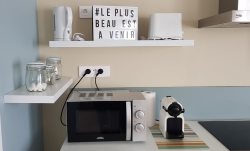 Kitchenette moderne de l'appartement La Java Bleue à La Maison Virginie, Montargis, avec micro-ondes, cafetière et blanc