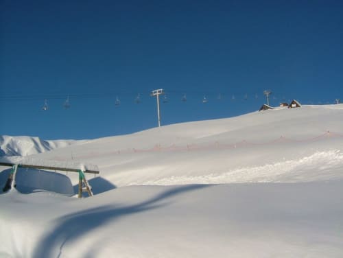 Sneeuwbedekte skipiste bij Chalet La Louvière met skilift en alpiene lodge in Fontcouverte-La Toussuire