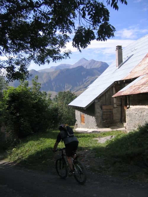 Fietser nadert Chalet La Louvière met bergen op de achtergrond, Fontcouverte-La Toussuire