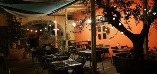 La terrasse du restaurant de la Tour Grégoire la nuit, Clermont-Ferrand, avec un éclairage chaleureux et des plantes
