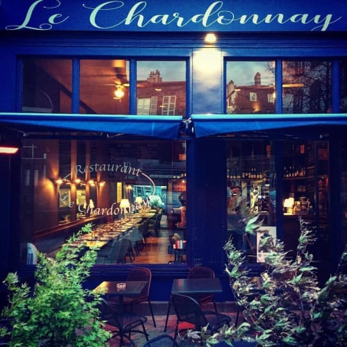 La façade bleue du restaurant Le Chardonnay illuminée au crépuscule à Clermont-Ferrand