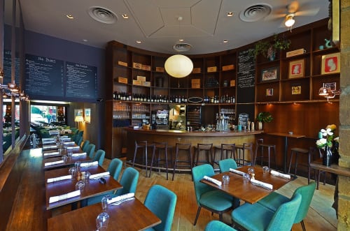 Restaurant La Tour Grégoire avec chaises turquoise, tables en bois, comptoir de bar et ambiance lumineuse à Clermont-Ferrand