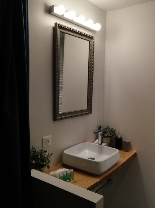 Salle de bains moderne à la Chambre Pariou, La Tour Grégoire, Clermont-Ferrand, avec vasque blanche et miroir encadré