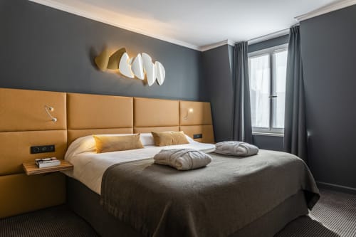 Modern Junior Suite at Hotel Residence Europe & Spa with mustard headboard, grey walls, and contemporary moon-phase wall