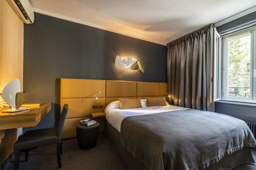 Modern Superior Room at Hotel Residence Europe & Spa in Clichy with gold headboard, grey accents, and contemporary décor