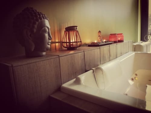 Salle de bain spa à La Cour d'Hortense : tête de Bouddha, lampe tressée et baignoire blanche à Sailly-Flibeaucourt