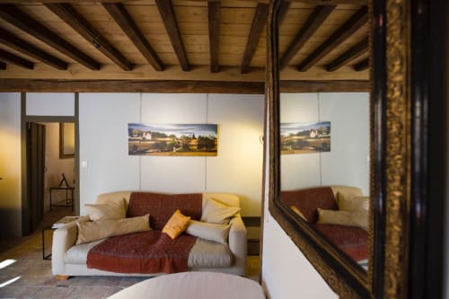 Cozy bedroom at Clos Saint Jacques B&B in Meursault with beamed ceiling, cream sofa, and vineyard artwork