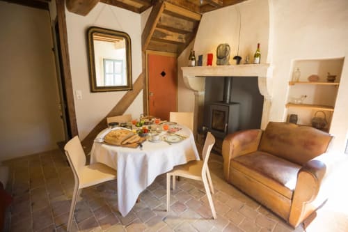 Cozy dining area with round table and leather armchair at Clos Saint Jacques B&B in Meursault, France