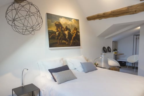 Modernes Schlafzimmer im Clos Saint Jacques BnB in Meursault mit weißem Bett, Kunstwerken und zeitgenössischer Einrichtung