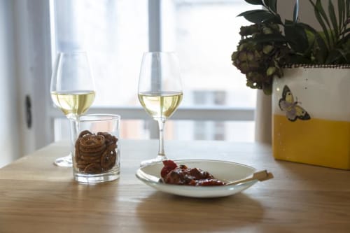 Zwei Gläser Weißwein, Schokoladenkekse und rote Marmelade auf einem Holztisch im Clos Saint Jacques in Meursault