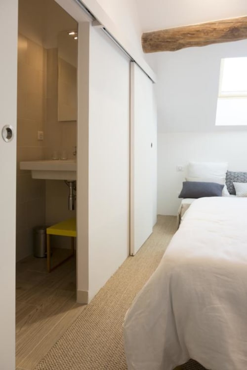 Modernes Schlafzimmer im Clos Saint Jacques B&B in Meursault mit eigenem Bad, Holzbalkendecke und weißer Bettwäsche