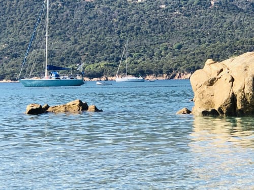 Voiliers mouillés dans les eaux turquoise près de la côte rocheuse de Porto Pollo, Corse