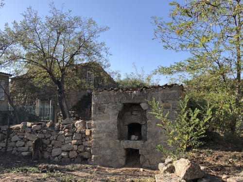 Antiguas ruinas de piedra con puertas arqueadas rodeadas de vegetación mediterránea en Villas Marincelu, Córcega