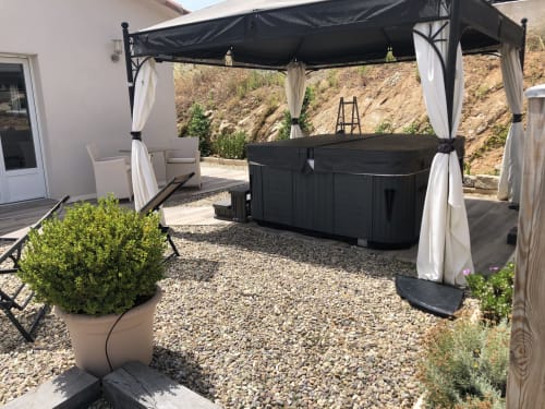 Outdoor hot tub under black pergola with white curtains at Villas Marincelu, Serra di Ferro, Corsica
