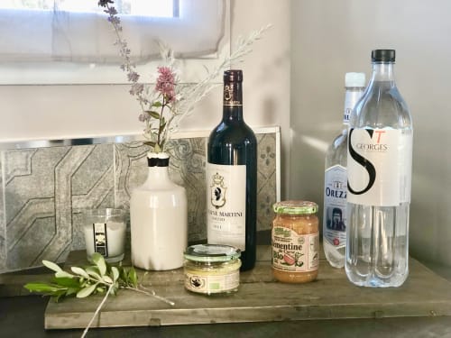 Élégant comptoir de cuisine aux Villas Marincelu avec bouteille de vin, eau, bocaux, fleurs fraîches et objets de décoration