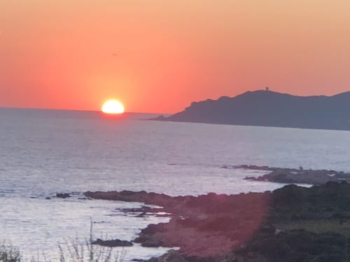 Coucher de soleil sur la mer Méditerranée aux Villas Marincelu, Porto Pollo, Corse avec littoral rocheux