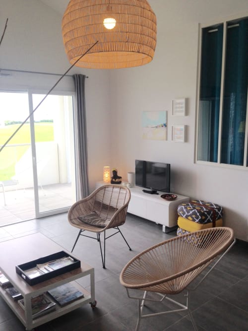 Séjour moderne avec luminaire suspendu tissé, chaises en rotin, TV et vue sur la terrasse à Côte Et Dune, Biscarrosse Plage
